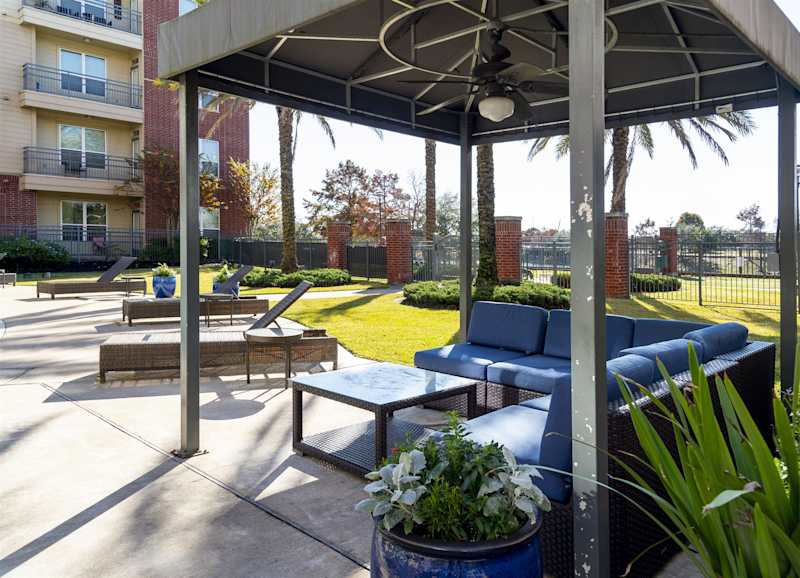 A shaded cabana with a table and chairs beside the pool