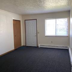 an empty room with a door and a window