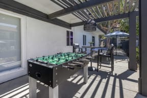 an outdoor kitchen with two stoves and a table with chairs and umbrellas at Sage Creek Apartment Homes, Simi Valley California