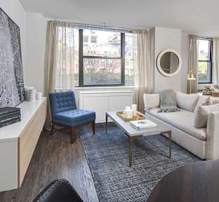 A living room with a blue chair and a white couch.