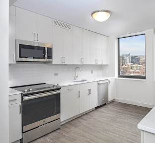 A kitchen with white cabinets and a stainless steel oven.