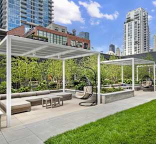 A park with a white canopy and a bench.