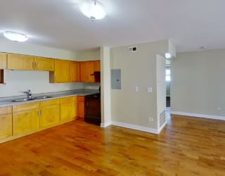 a kitchen with a wooden floor and wooden cabinets