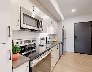 A modern kitchen with a stove, oven, microwave, and refrigerator.