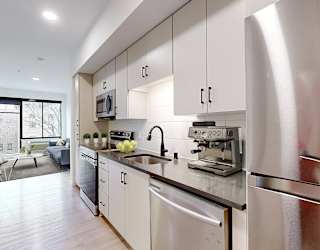 A modern kitchen with stainless steel appliances and white cabinets.