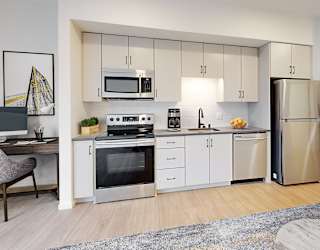 A modern kitchen with stainless steel appliances and white cabinetry.