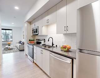 A modern kitchen with stainless steel appliances and white cabinets.