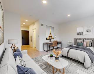 A modern bedroom with a large bed and a couch.