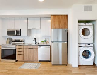 a kitchen with a washing machine and a refrigerator