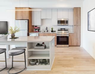 a modern kitchen with a white island with two stools