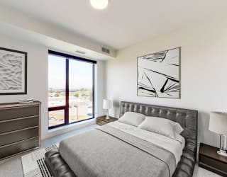 a bedroom with a bed and a large window