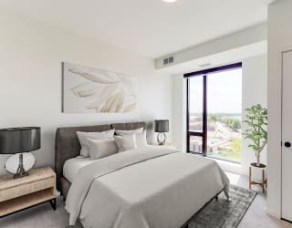 a white bedroom with a large bed and a door to a balcony