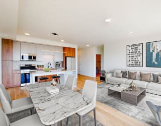 a living room and dining room with a table and chairs