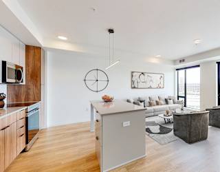 a living room with a couch and a table and a kitchen
