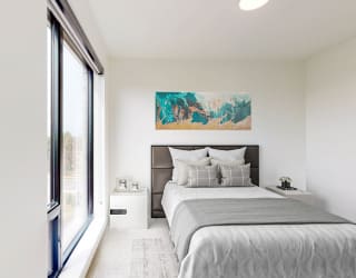 a bedroom with a bed and a large window