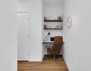 a home office with a desk and a chair and a clock on the wall