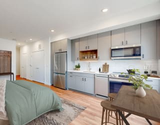 a bedroom with a bed and a kitchen with blue cabinets