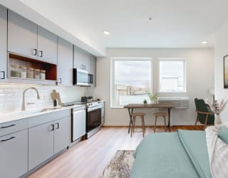 a living room and kitchen with a couch and a table
