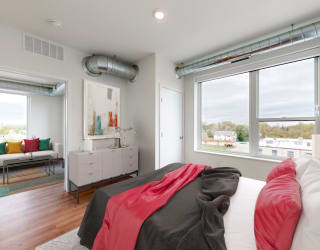 a bedroom with a bed and a large window