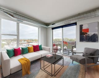 an open living room with a white couch and a table with colorful pillows