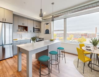a kitchen with a large window and a table with chairs