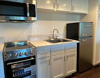 A modern kitchen with a stainless steel refrigerator, oven, and microwave.