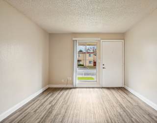 A room with a white door and a window showing a street view.