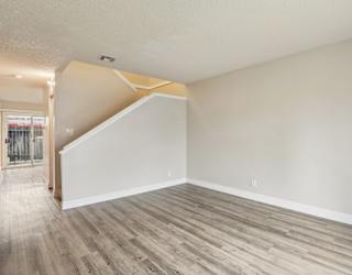 A room with a wooden floor and a staircase.