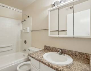A bathroom with a sink, toilet, and bathtub.