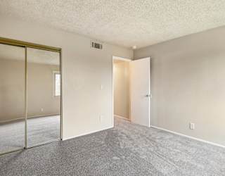 A room with a carpet floor and a white door.