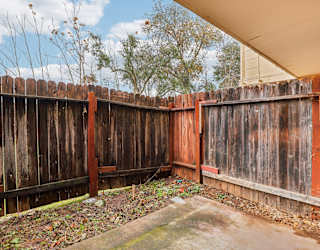 A brown wooden fence with a concrete slab in the middle.