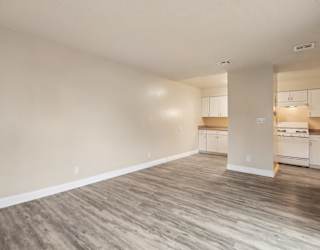 A room with wooden flooring and white walls.