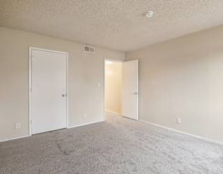 A room with two doors and carpeted floor.