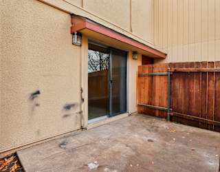 A brown fence is in front of a tan building.