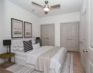 a white bedroom with a bed and a ceiling fan at The Waterford At Rocketts Landing Apartments, PRG Real Estate, Richmond, Virginia