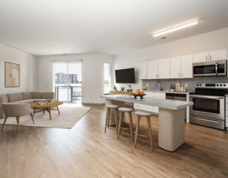 a living room with a kitchen and an island with chairs and a table at The Waterford At Rocketts Landing Apartments, PRG Real Estate, Richmond, Virginia