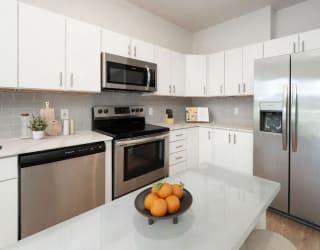 a kitchen with stainless steel appliances and white cabinets at The Waterford At Rocketts Landing Apartments, PRG Real Estate, Richmond, Virginia