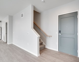 Entryway and carpeted staircase leading to second floor at Aspire at CityPlace in Woodbury, Minnesota