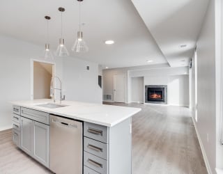 Large kitchen island with granite countertops and dishwasher in island