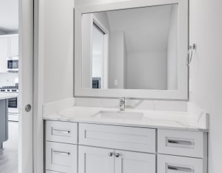 Bathroom vanity with light gray finishes and large mirror at Aspire at CityPlace in Woodbury, Minnesota