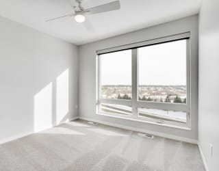 Spacious luxury bedroom with large window and ceiling fan at Aspire at CityPlace in Woodbury, Minnesota