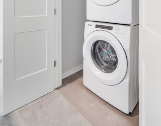 Stacked washer and dryer in laundry closet in luxury apartment home at Aspire at CityPlace in Woodbury, Minnesota