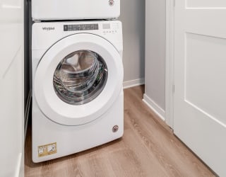 Stacked front loading washer and dryer in a closet at Aspire at CityPlace in Woodbury MN 55125