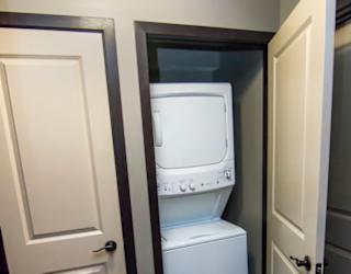 Hall closet with stacked washer and dryer unit
