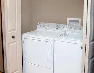 A white washer and dryer in a small laundry closet
