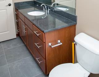 A bathroom with a sink, mirror, and toilet.