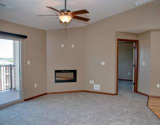 A living room with a fireplace and a ceiling fan.