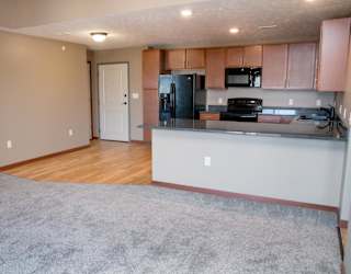A kitchen with a refrigerator, microwave, and stove, plus a peninsula for seating