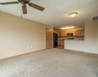 a empty living room with a ceiling fan