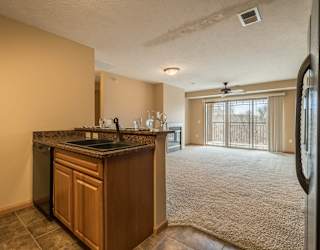 a kitchen looking into carpeted living room